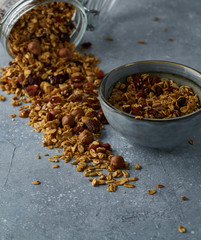 Homemade granola from mix of oat cereals  with dry fruits, nuts and seeds on a grey  concrete table concept of healthy breakfast. Slow living