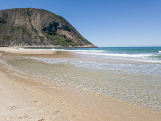 Summer in Itacoatiara beach, transparent waters, soft sand, surf and preserved nature, blue sky, in remote and quiet neighborhood, in the city of Niterói, Rio de Janeiro Brazil.