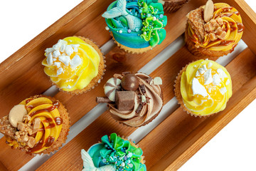 Above view of a wooden slated tray with colorful cupcakes
