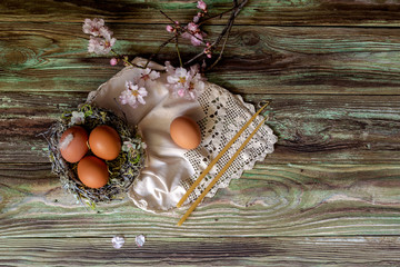 Naklejka premium Easter composition with almond branches, nest, eggs and candles