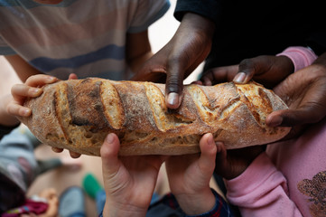 Black and white children holding loaf of bread - Powered by Adobe