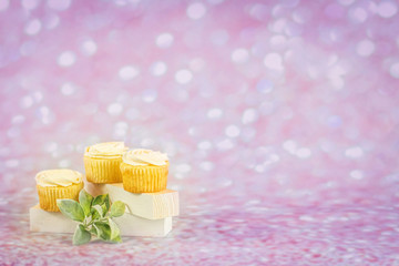 Three cupcakes flower up close on a bokeh purple cream sweet glitter sparkle background