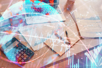 Double exposure of chart and financial info and work space with computer background. Concept of international online trading.