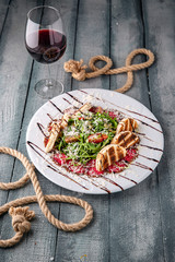 Delicious beef carpaccio with croutons. On a turquoise background. Sea mood concept menu.
