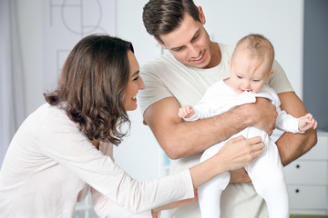 Cute baby with parents at home