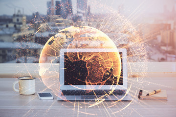 Computer on desktop with social network hologram. Multi exposure. Concept of international people connections.