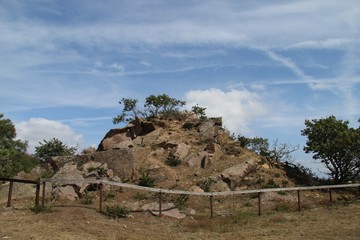 Rocky mound behind a fence at midday in Sandvig, Bornholm