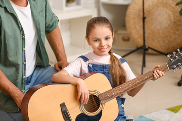 Cute little girl playing guitar at music school