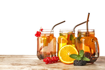 Mason jars of cold cocktails on table against white background