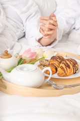 Young couple with tasty breakfast in bed at home