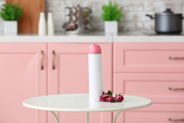 Bottle of air freshener on table in kitchen