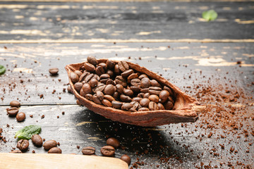 Pod with coffee beans on wooden background