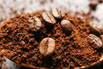 Spoon with coffee beans and powder, closeup