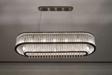 Close-up of a beautiful crystal chandelier. Large expensive classic chrome chandelier with lights...