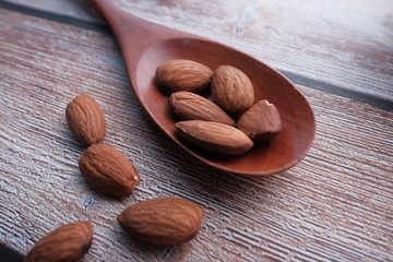 Close up of fresh almond on spoon on table. 