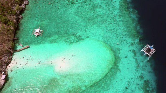 Aerial view of the Sumilon island, sandy beach with tourists swimming in beautiful clear sea water of the Sumilon island beach, Oslob, Cebu, Philippines, 4K.