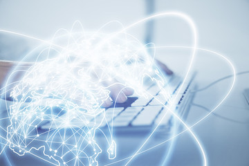 Double exposure of businessman working on laptop on background. International business hologram in front. Concept of success.