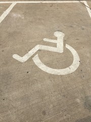 Traffic signs are displayed on parking spaces for people with disabilities.