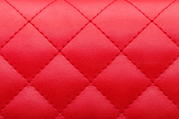 square red leather pattern stitched with thread seam, decorative texture of animal skin.