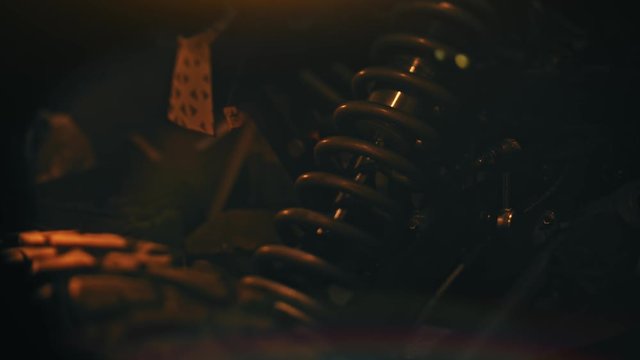 Close up of coil spring used as a part of car or motorcycle suspension system. Stock footage. Details of machines, professional equipment and repair parts.