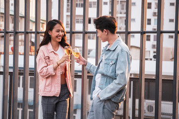 Romantic Asian young couple celebrate together during their honeymoon in valentines party with white wine. Affectionate relationship between husband and wife in anniversary celebration party.