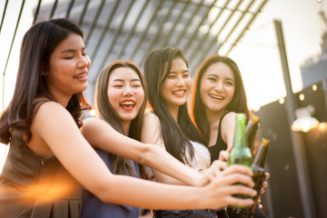Group of people in party and celebrating together with white wine and beer. Happy Asian people enjoy partying in festival and celebrate with white wine on the roof top bar and restaurant.