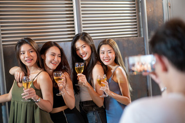 Group of people in party and celebrating together with white wine and beer. Happy Asian people enjoy partying in festival and celebrate with white wine on the roof top bar and restaurant.