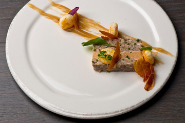 Duck Terrine. Traditional French cuisine a loaf of forcemeat or aspic, similar to a pâté, cooked in a covered pottery mold in a bain-marie.  Served at a French Bistro with potatoes and carrots