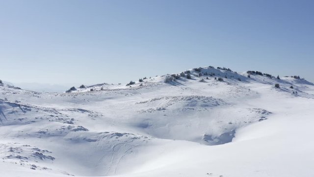 Forwarding drone to capture beautiful mountains covered with snow in the morning on sunny day with no clouds and no fog. Drone flyover national park and ski resort. Filmed in 4k