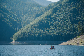 the concept of boating, recreation, travel-a man rides a catamaran. Boating on the lake