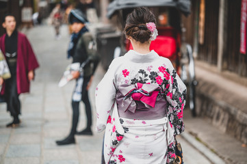  Young women wearing traditional Japanese Kimono with colorful maple trees in autumn is famous in autumn color leaves and cherry blossom in spring, Kyoto, Japan.