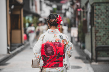 Fototapeta premium Young women wearing traditional Japanese Kimono with colorful maple trees in autumn is famous in autumn color leaves and cherry blossom in spring, Kyoto, Japan.