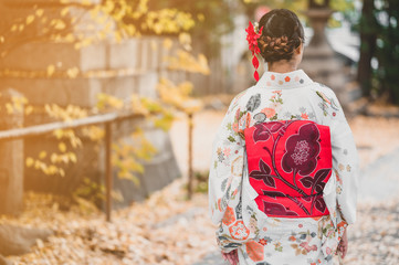 Obraz premium Young women wearing traditional Japanese Kimono with colorful maple trees in autumn is famous in autumn color leaves and cherry blossom in spring, Kyoto, Japan.