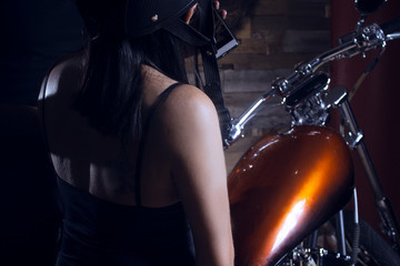 Fototapeta na wymiar Woman wearing helmet sitting on a motorcycle, looking at her cell phone