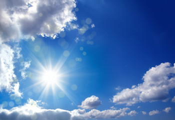 Beautiful shiny blue sky cloudscape image with sun and beam of light