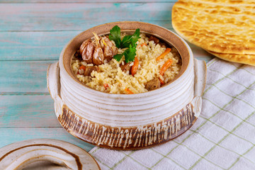 Oriental dish with rice, carrot, garlic and meat.