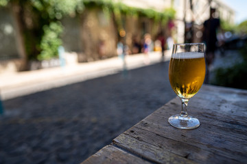 Beer glass with foamy beer on table in city restaurant area