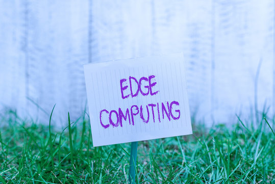 Text sign showing Edge Computing. Business photo showcasing practice of processing data near the edge of your network Plain empty paper attached to a stick and placed in the green grassy land