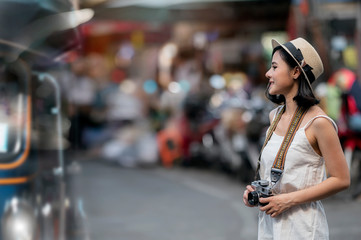 Woman with vintage camera standing in the city on vacation.