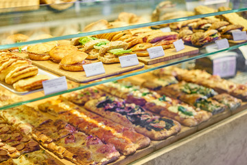Croissant with ham and cheese. Hot pastries lie on the shelf in the cafe. Buns and bagels in the store.