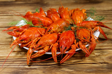 Boiled crayfish in plate on wooden table