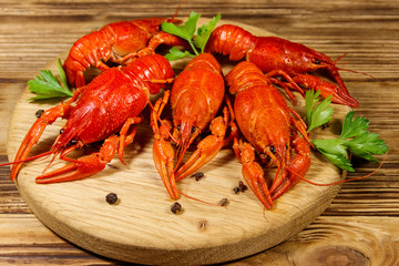 Boiled crayfish on cutting board on wooden table