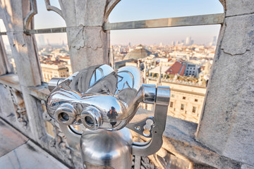 Amazing viewpoint with binoculars in Milan Cathedral roof Panorama Milan. sunny day, Italy. Cathedral or Duomo di Milano is top tourist attraction of Milan.