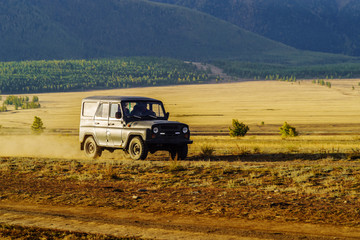 Altai Republic, Russia - September, 18, 2019: UAZ SUV driving on the Kurai steppe in the early morning