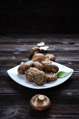 Shiitake mushrooms on the wooden background.