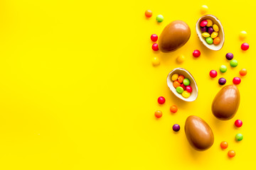 Chocolate eggs - Easter symbol - frame on yellow background top-down copy space