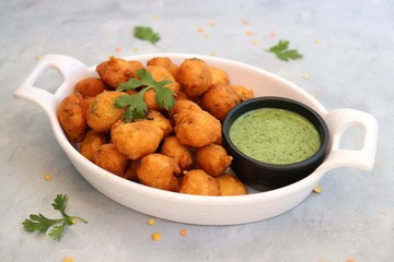 Moong dal ke pakode, ram laddoo, bhajias, Moongode or fritters. served with green mint and...