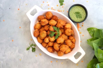 Moong dal ke pakode, ram laddoo, bhajias, Moongode or fritters. served with green mint and...