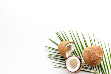 Fototapeta na wymiar Coconuts and leaves - tropical still life on white background top-down copy space