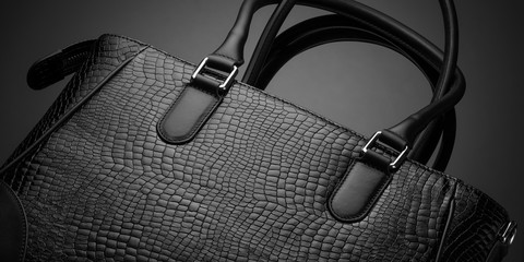 Black fashionable designer women's bag on a dark background